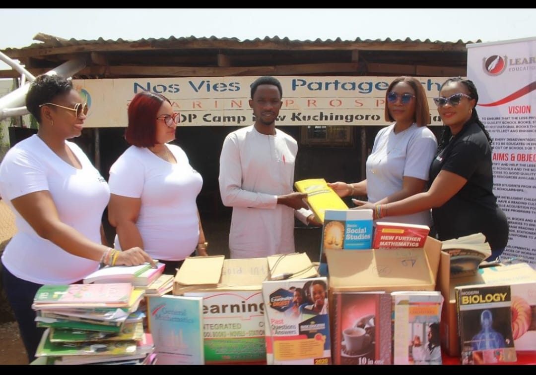 A textbook being handed over at the book table, New Kuchigoro IDP camp, Abuja.
